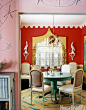 The deep reddish orange of the walls and the turquoise table make bold statements in this dining room in a 1940s Miami bungalow designed by owners Gene Meyer and Frank Biasi.