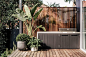 The built-in BBQ with a polished concrete bench top is set in front of a vertical Spotted Gum screen with copper spaces were used to separate the batons.