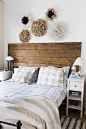 Bedroom decorations in neutral colors with a reclaimed wood headboard and a collection of homemade African feather Juju hats/wreaths. via http://www.songbirdblog.com