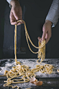 Pasta. Ready to Cook. - Female hands making pasta pici over wooden kitchen table, powdering by flour. Dark rustic style with retro filter effect. See process series: 