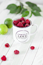 Mug of fresh raspberries on a table with limes and mint