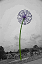 A giant dandelion crafted out of bicycle wheels sits along Route 77 in Cleveland.