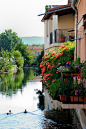 法国南部普罗旺斯地区的一个城市，窗台外的鲜花，和河水绿树还有小鸭子互相映衬