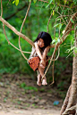 Hanging Around in Cambodia | A Khmer Child plays in the jungle trees at the Temple Complex of Ta Prohm in Angkor at Siem Reap Cambodia. | Photo and caption by Stephen Bures: 