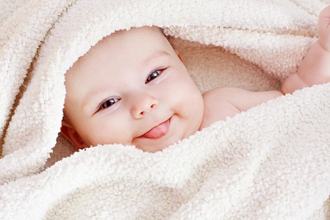 毛巾中伸舌头的婴儿图片