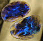 Lightning Ridge Black Opal Pair    Australia. Almost a matched pair, one a little larger (2.7 x 1.8 x 5cm) than the other. (2.4 x 1.6 x.6cm) Flashing irridescent blue.