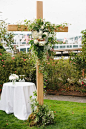 Wedding ceremony cross decorated with flowers and vines for a Roche Harbor wedding.  Wedding Planning & Design: Perfectly Posh Events. Photo: Lucid Captures Photography. Flowers: Robin's Nest.: 