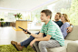 Family watching television in living room by Caia Images on 500px