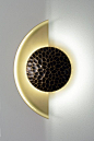 The Helix sconce is a dimmable LED wall sconce featuring a crescent shaped dome and etched bronze shield. The shape of this sconce creates a stunning array of shadows and reflections. The example shown above features a sandblasted brass body and
