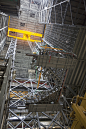 KSC-2015-3632 : A 325-ton crane lifts the first half of the K-level work platforms high up in High Bay 4 inside the Vehicle Assembly Building at NASA's Kennedy Space Center in Florida. The platform will be lifted over the transfer aisle that runs down the