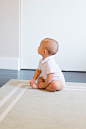 婴儿坐在米色的地毯上