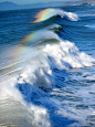 Prisms of light create rainbows on ocean waves.