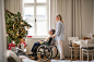 A senior woman in wheelchair with a health visitor at home at Christmas time.