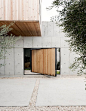 This Texas home incorporates Japanese influences with cubes of different materials. There are three main boxes, two concrete forms and a lifted wooden cube. Click through for more images of this minimalist home. This big pivoting door leads from a zen gar