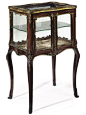 A FRENCH GILT-METAL MOUNTED MAHOGANY VITRINE CABINET In the Louis XV style, late 19th century Of serpentine form with bevelled glazed panels, the conforming doors enclosing a velvet lined interior and a central glass shelf, on tall cabriole legs and sabot