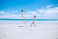 man and woman playing on white sand near seashore during daytime