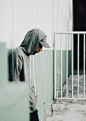 Man in Gray Hoodie Standing Near White Metal Gate