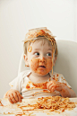 Mixed race baby boy eating spaghetti - stock photo