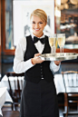 人,餐盘,制服,含酒精饮料,商务_167457979_Denmark, Aarhus, Portrait of waitress holding champagne flutes on tray_创意图片_Getty Images China