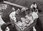 1935年6月中旬，李济亲自筹划并到现场指导将127号灰坑内的“甲骨灰土柱”整个装箱启运回南京。右踞箱上者为李济