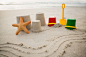 Bucket, spade, starfish and sand castles on beach Free Photo