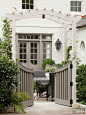 If you want to separate your outdoor space from your driveway or a street but you want to maintain accessibility, consider a gated arbor. These homeowners opted for a shorter, curved-top gate to create separation without blocking views. A mix of bright wh