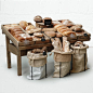 several bags of bread sitting on top of a wooden table next to two bins filled with bagels