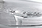 zaha hadid设计的“流体冰桌”模仿了两股互相缠绕的水洼，三个清澈的水柱从水洼中流下，凝结成冰，变成支撑桌面的桌腿。这个设计巧妙的捕捉了水的涟漪，用类似玻璃的丙烯酸材料创造出微妙精致的质感。桌面经手工打磨抛光，对周围世界产生了梦幻般的折射效果。