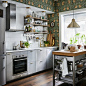 棕色和灰色小型厨房里贴着传统墙纸，配有 GREVSTA 格斯达 不锈钢抽屉前板。