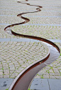 Rill curves thru cobblestone - PAM - meanderende afwateringsgoot - Public Square in Varde  |  Photo by Buelipix