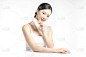 亚洲女性模特展示护肤品的白底摆拍照片