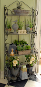 I always like a wrought-iron bakers stand. I use this to house all my gardening bibs and bobs, little herb pots and my collection of grey tin pots, urns and birds. It makes a great display for the door out to the garden.