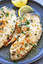 Tilapia recipe with lemon and Parmesan cheese, served on a plate.