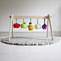 Handmade wooden baby play gym with Noodoll fruit and veggie plush toys and Olli Ella moondrop rug. All available at littlegoldie.com