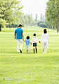 幸福家庭高清摄影图片素材,草坪上的一家人牵手背影图