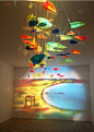  创意装置作品，用光线和彩色玻璃在墙上映出一幅画来，十分巧妙。