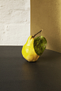Freshly picked juicy yellow pear with a leaf on a table