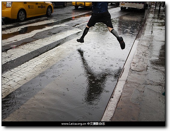 雨中，一名女子越过纽约联合广场路边的一个...