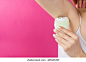 Woman epilates her armpit with an electric epilator device