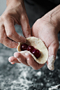 Woman cook manually sculpts dumplings stuffed with cherries