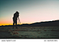 Silhouette of professional adventures photographer taking photo of beautiful sunset in Death Valley on camera with tripod equipment, man traveler shooting colourful skyline scenery view in the dusk