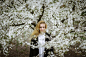 Woman in Black and White Floral Long Sleeve Shirt Standing Beside White Flowers