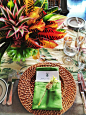 Centerpieces of tropical foliage in fun colors. We could alternate the tables with arrangements done in this style, and mix it in with something more floral. I think it would look really chic!