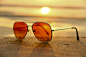 海滩上的眼镜 橙色的镜片 太阳光点#米洛图片miluopic.com##唯美图片##高清大图##banner背景##大图背景##可商用大图##摄影##网页素材##设计素材##杂志配图##桌面背景#