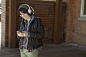 Smiling woman listening to music on headphones outdoors - stock photo