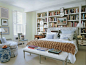 jeffrey bilhuber bedroom--built-in bookshelves, pale green walls, carved bed bench, fur throw, upholstered headboard