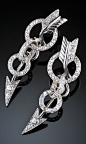 A pair of Art Deco diamond and white gold arrow ear cuffs, American, 1930s. Each ear cuff designed as an arrow piercing two targets, set with diamonds and mounted in 18k white gold. The earrings curve up the ears when worn. #ArtDeco #EarCuffs