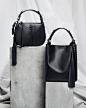 Lookbook image of two women's handbags from our latest range, positioned on grey plinths in front of a white backdrop.