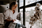 woman in white shirt sits and write in room