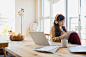 Woman with headphones and notebook at laptop by Hero Images  on 500px